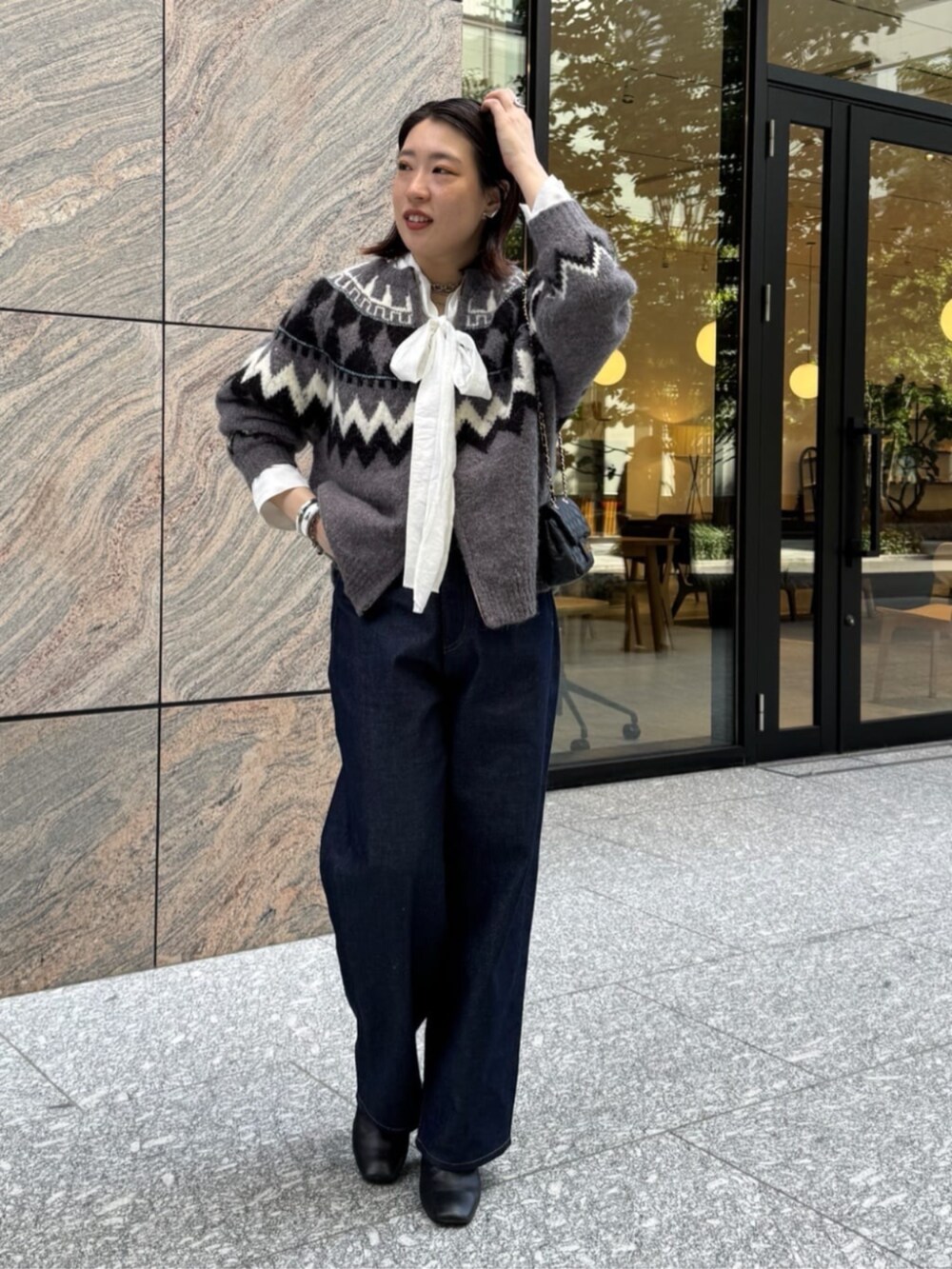 ブラック系のショルダーバッグ、ブルー系のデニムパンツ、ホワイト系のシャツ/ブラウスを着用したレディースの秋コーディネートの9枚目の写真