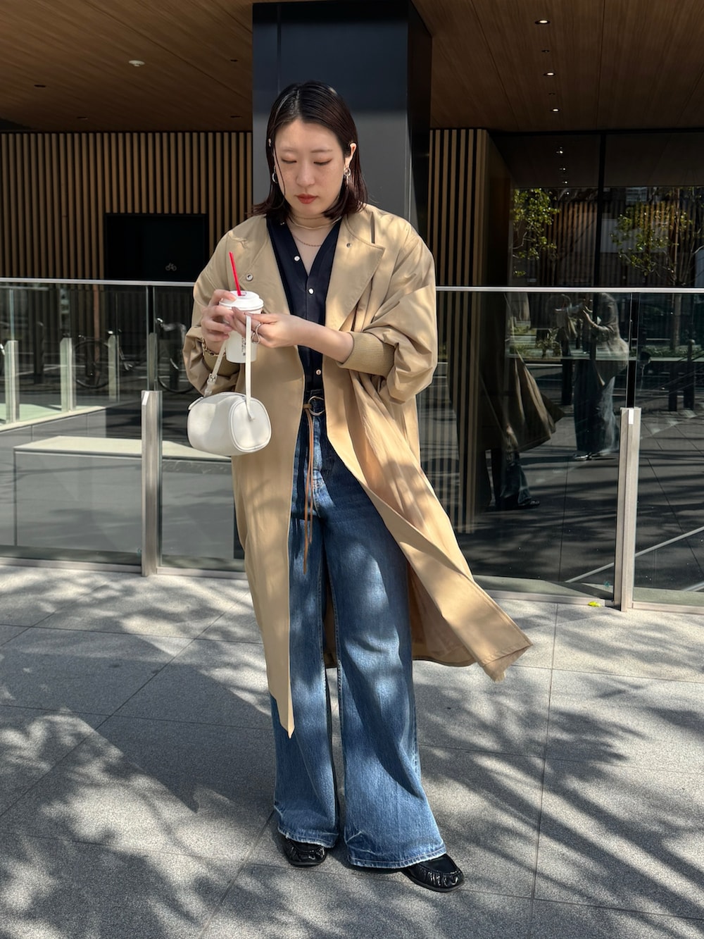 ブルー系のデニムパンツ、イエロー系のその他アウター、ブルー系のシャツ/ブラウスを着用したレディースの春コーディネートの2枚目の写真