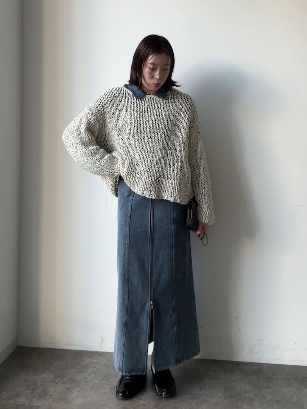 グレー系のニット/セーター、ブルー系のスカート、ブルー系のシャツ/ブラウスを着用したレディースの冬コーディネートの3枚目の写真