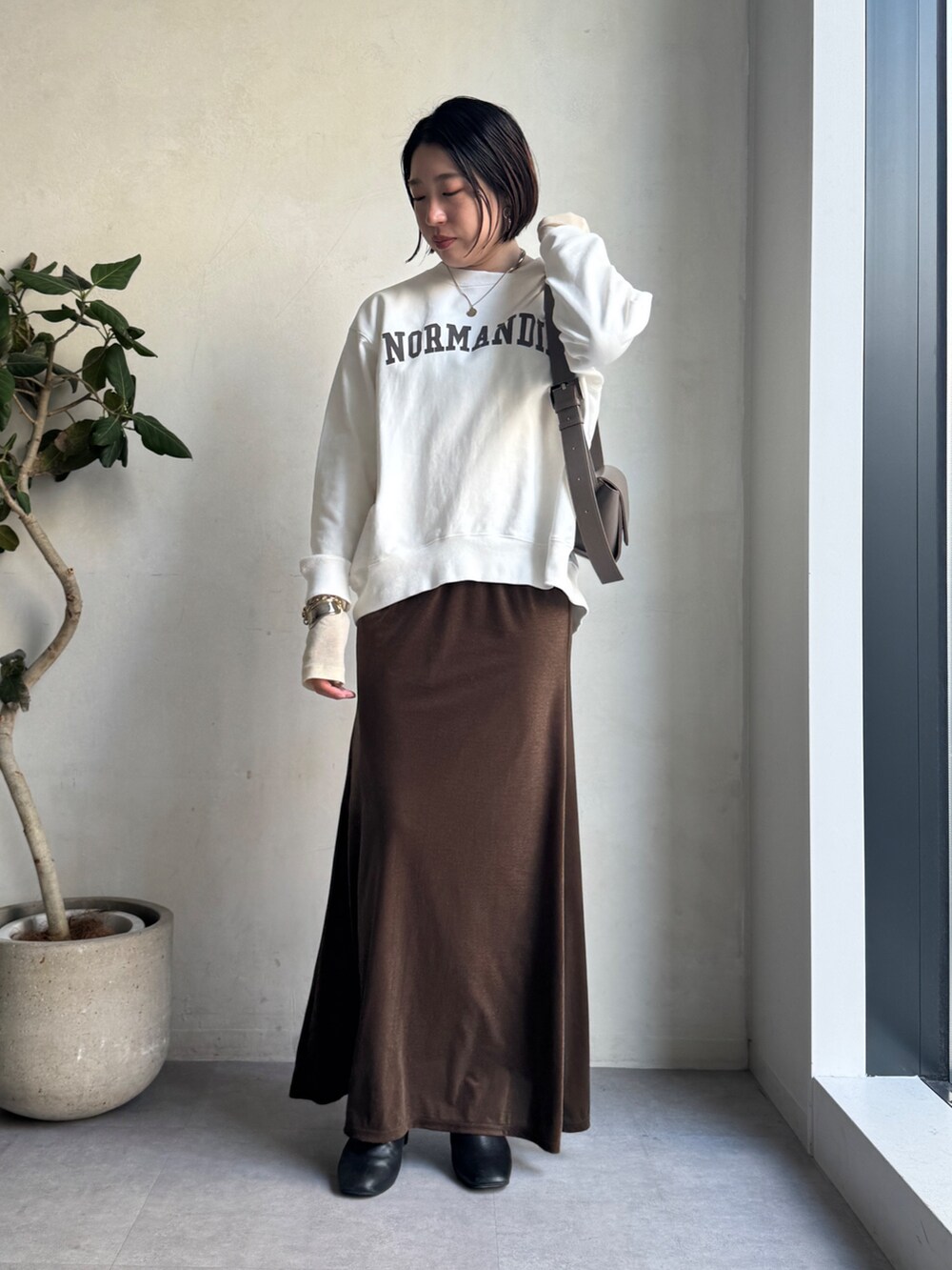 ベージュ系のその他アウター、ブラウン系のスカート、ホワイト系のTシャツ/カットソーを着用したレディースの冬コーディネートの7枚目の写真