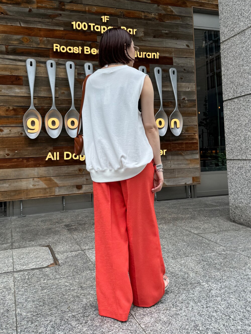 オレンジ系のその他パンツ、ホワイト系のスウェット、ブラウン系のショルダーバッグを着用したレディースの夏コーディネートの6枚目の写真
