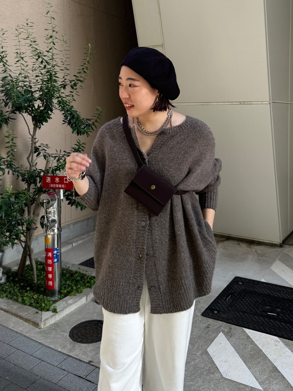 ホワイト系のスウェットパンツ、ベージュ系のニット/セーター、ブラウン系のショルダーバッグを着用したレディースの夏コーディネートの3枚目の写真