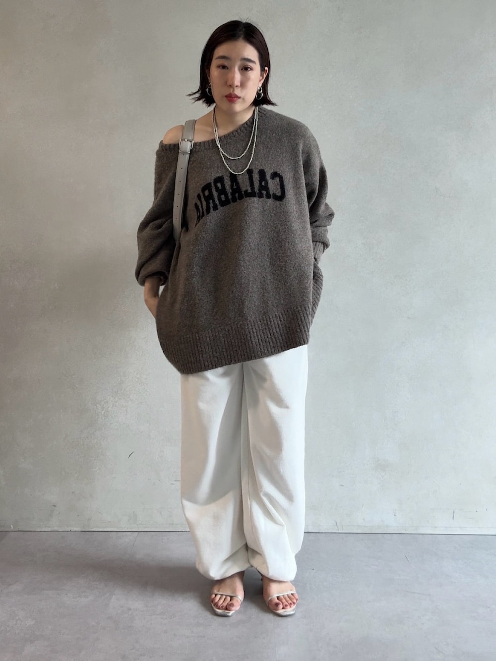 ベージュ系のニット/セーター、ホワイト系のスウェットパンツ、グレー系のショルダーバッグを着用したレディースの秋コーディネートの3枚目の写真