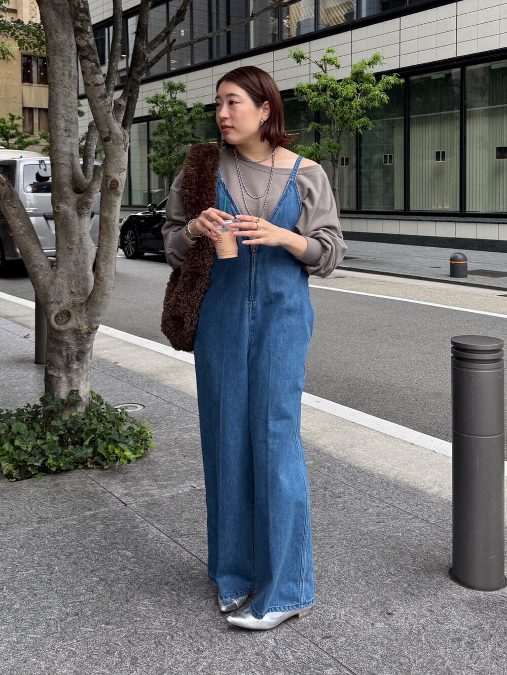 ブルー系のつなぎ/オールインワン、ベージュ系のスウェット、ブラウン系のショルダーバッグを着用したレディースの秋コーディネートの5枚目の写真
