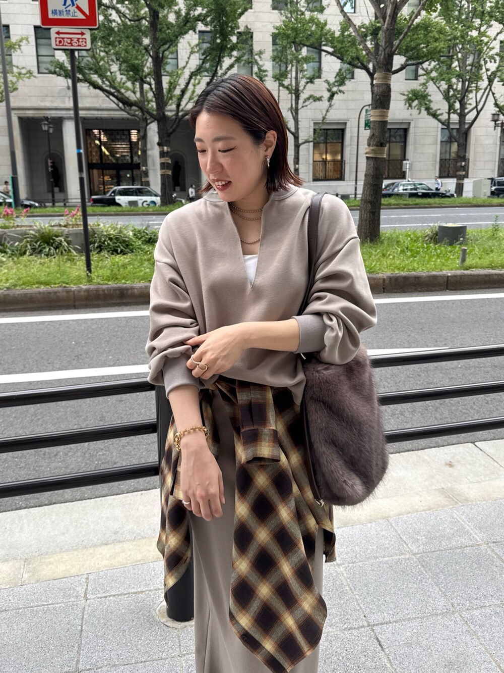 ベージュ系のTシャツ/カットソー、ベージュ系のスカート、ブラウン系のショルダーバッグを着用したレディースの秋コーディネートの9枚目の写真