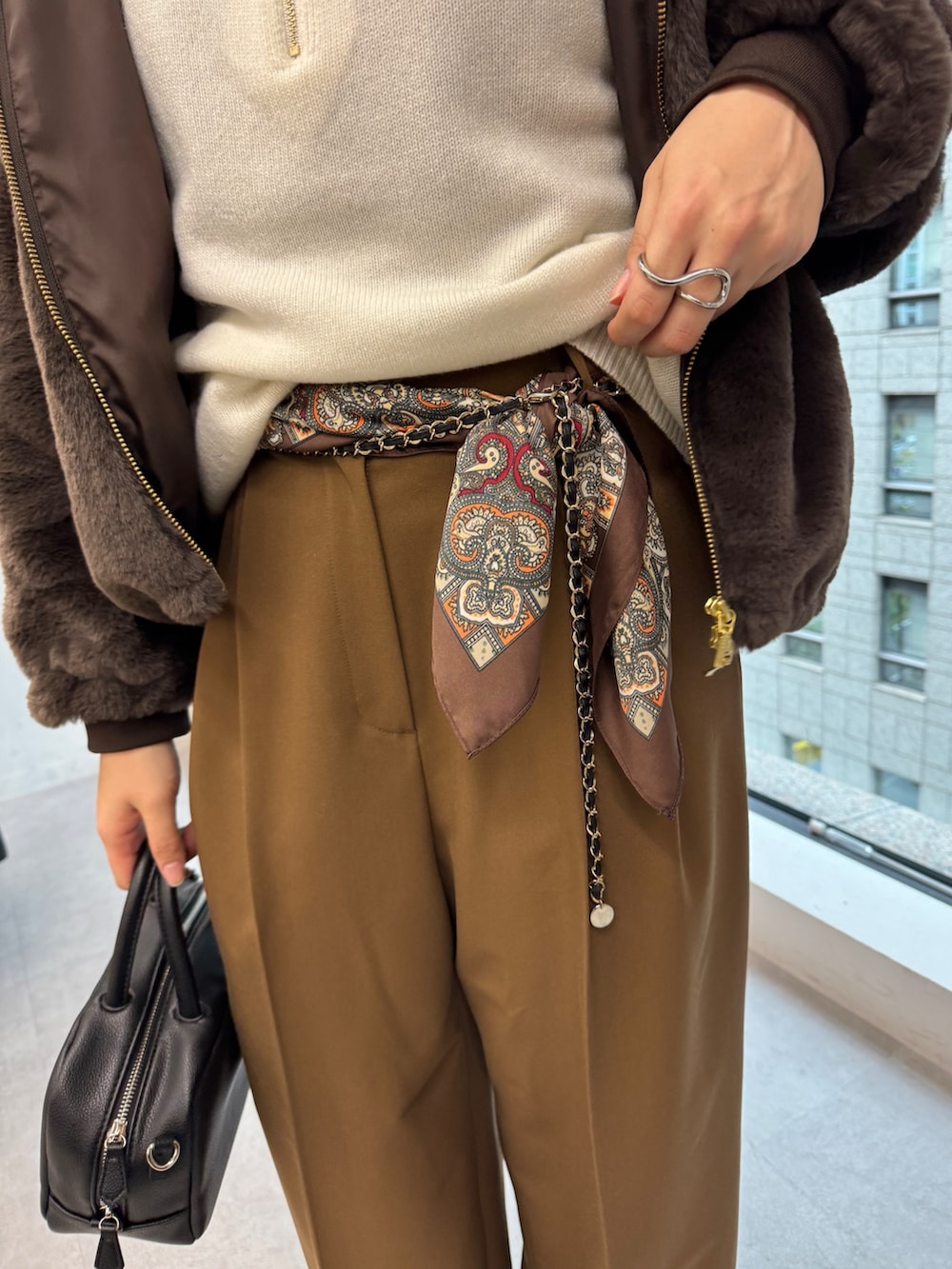 ブラウン系のその他パンツ、グレー系のその他アウター、ホワイト系のニット/セーターを着用したレディースの冬コーディネートの9枚目の写真