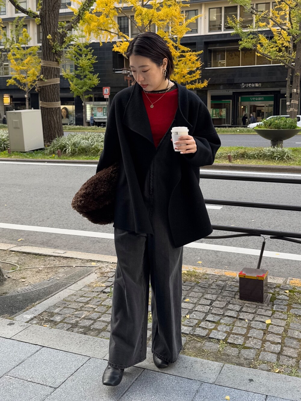 ブラック系のつなぎ/オールインワン、レッド系のニット/セーター、ブラック系のその他アウターを着用したレディースの冬コーディネートの6枚目の写真