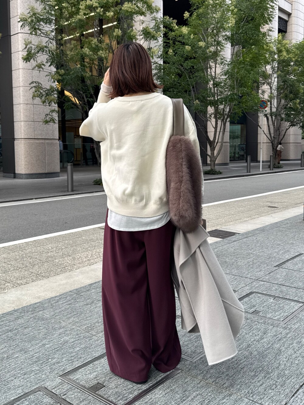 レッド系のスラックス、ベージュ系のその他アウター、ホワイト系のニット/セーターを着用したレディースの秋コーディネートの7枚目の写真