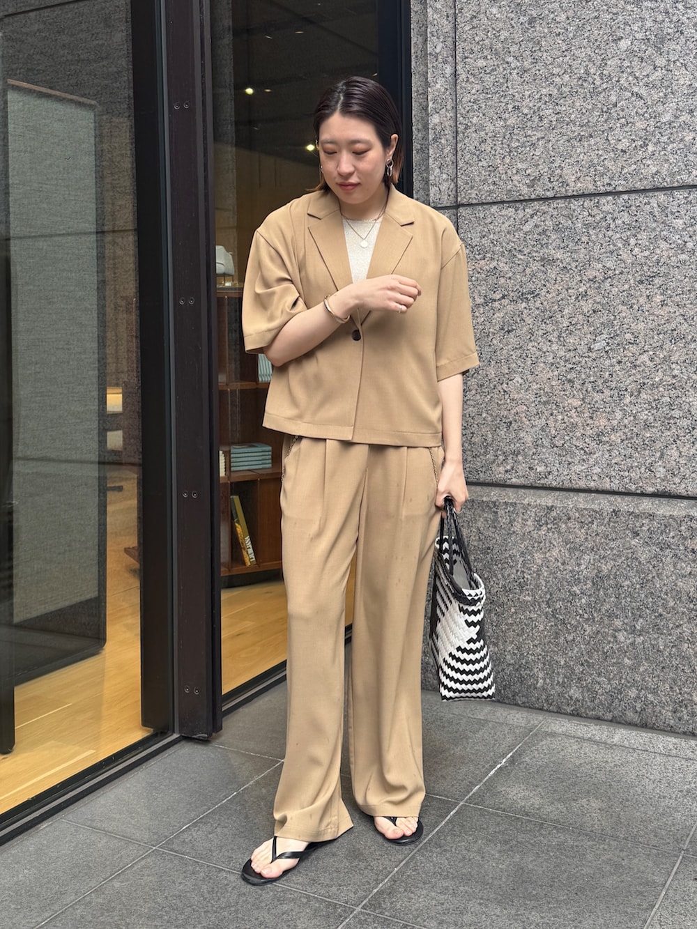 ベージュ系のニット/セーター、ベージュ系のその他パンツ、ベージュ系のテーラードジャケットを着用したレディースの春コーディネートの4枚目の写真