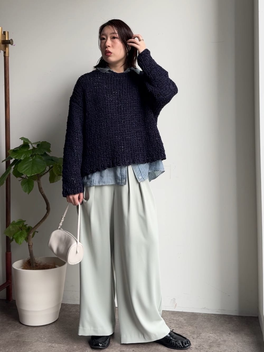 ブルー系のニット/セーター、ブルー系のシャツ/ブラウス、グリーン系のスラックスを着用したレディースの冬コーディネートの4枚目の写真