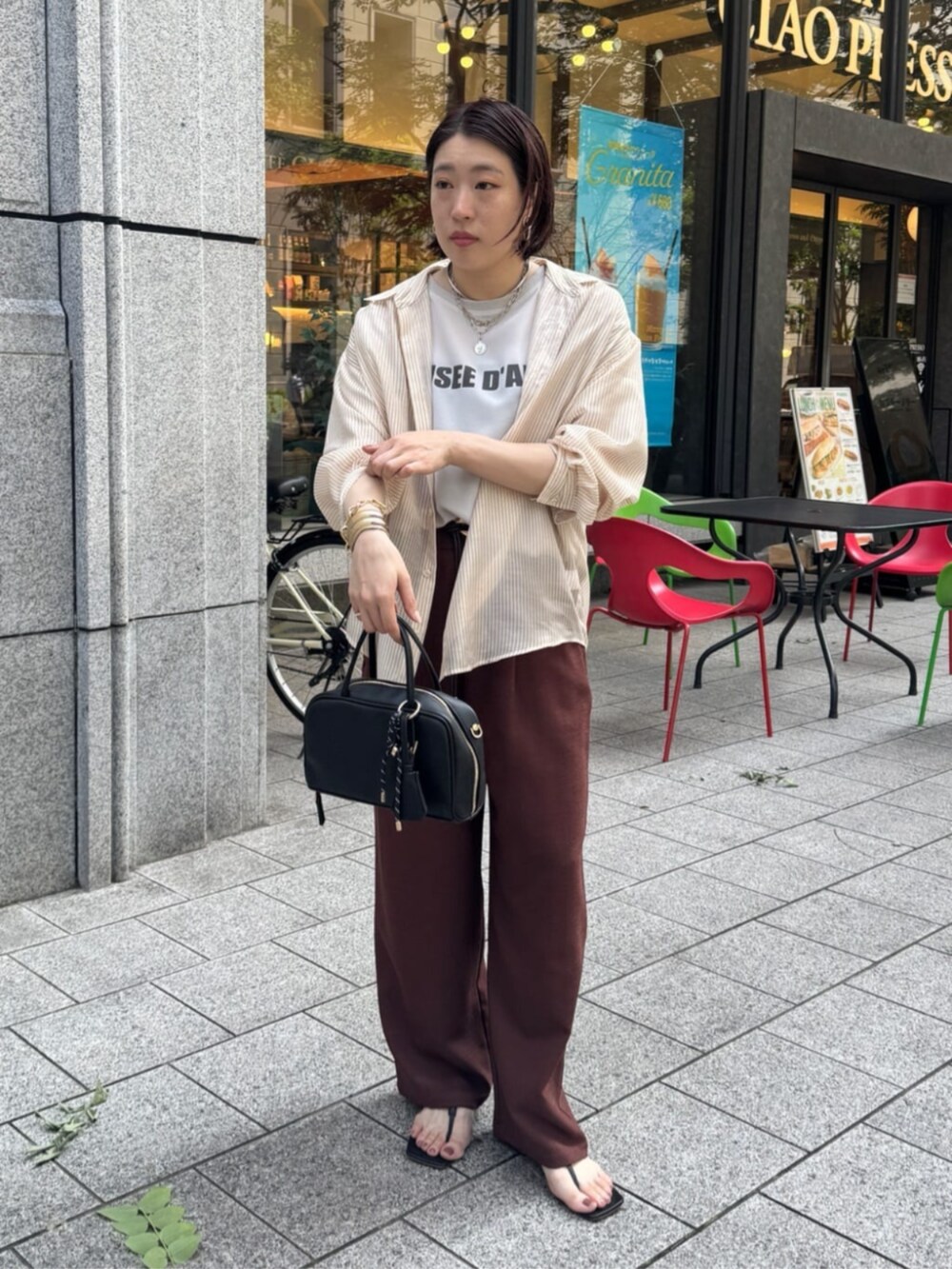 グレー系のシャツ/ブラウス、ブラック系のショルダーバッグ、レッド系のその他パンツを着用したレディースの夏コーディネートの2枚目の写真