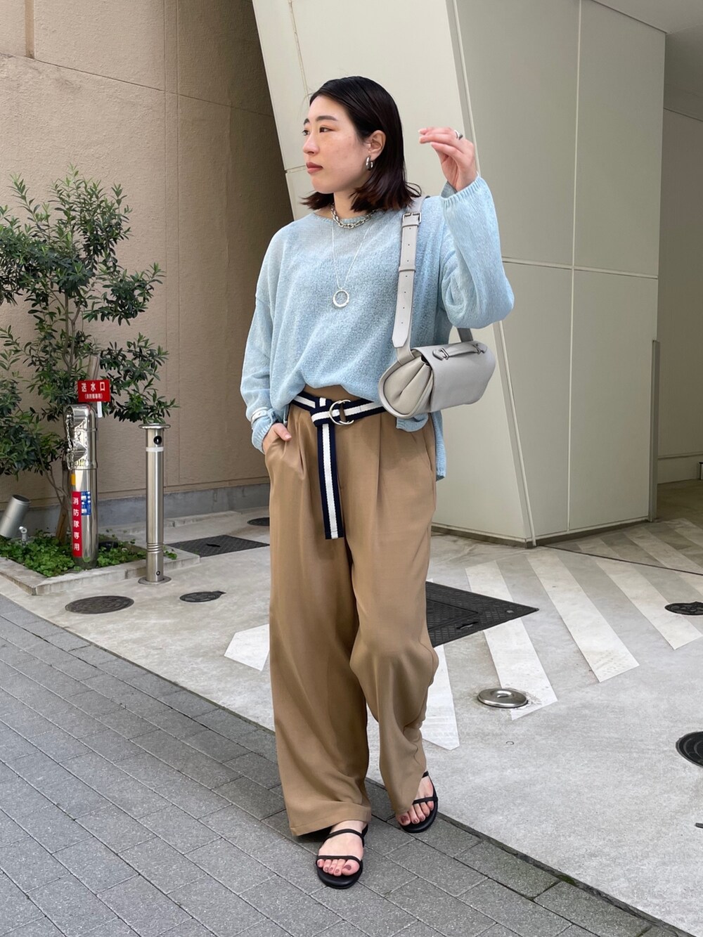 グレー系のスラックス、ブルー系のニット/セーター、ブルー系のベルトを着用したレディースの春コーディネートの5枚目の写真