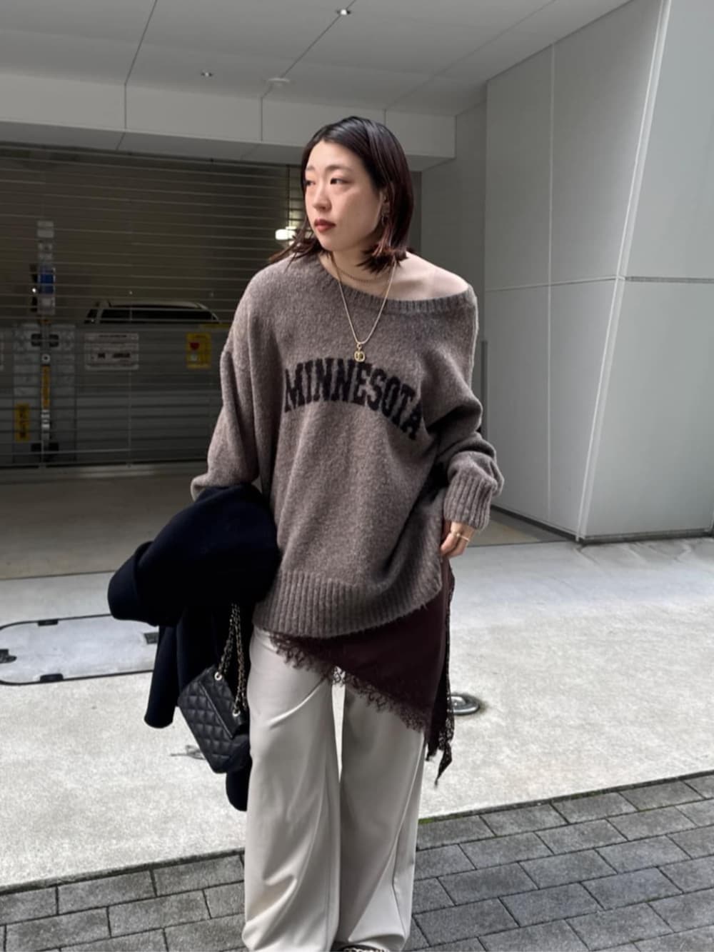 ブラック系のショルダーバッグ、ベージュ系のニット/セーター、ブラウン系のキャミソールを着用したレディースの秋コーディネートの3枚目の写真