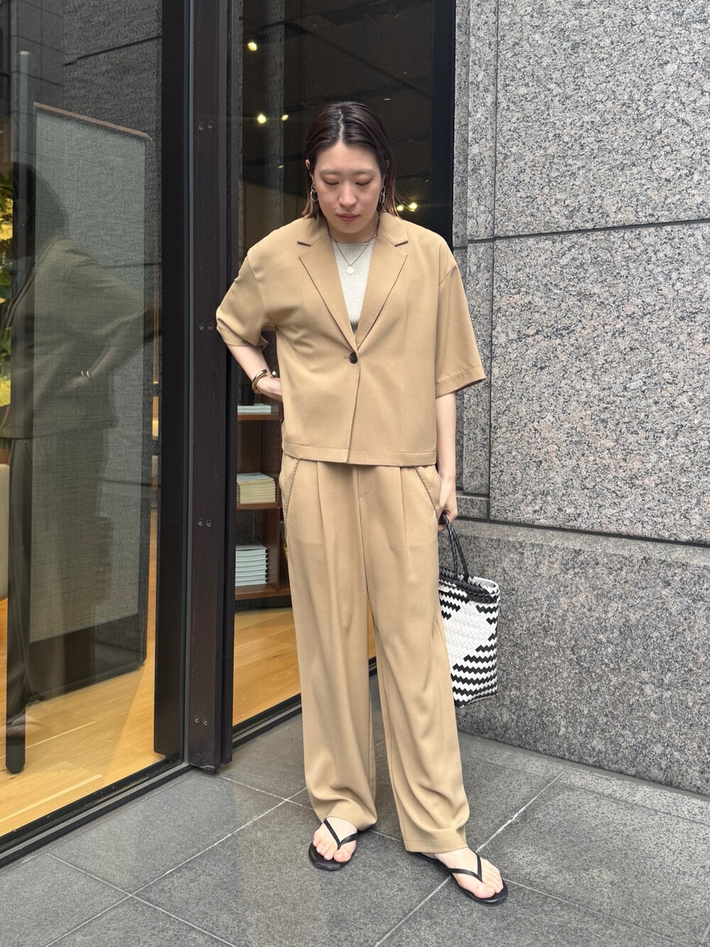 ベージュ系のニット/セーター、ベージュ系のその他パンツ、ベージュ系のテーラードジャケットを着用したレディースの春コーディネートの7枚目の写真