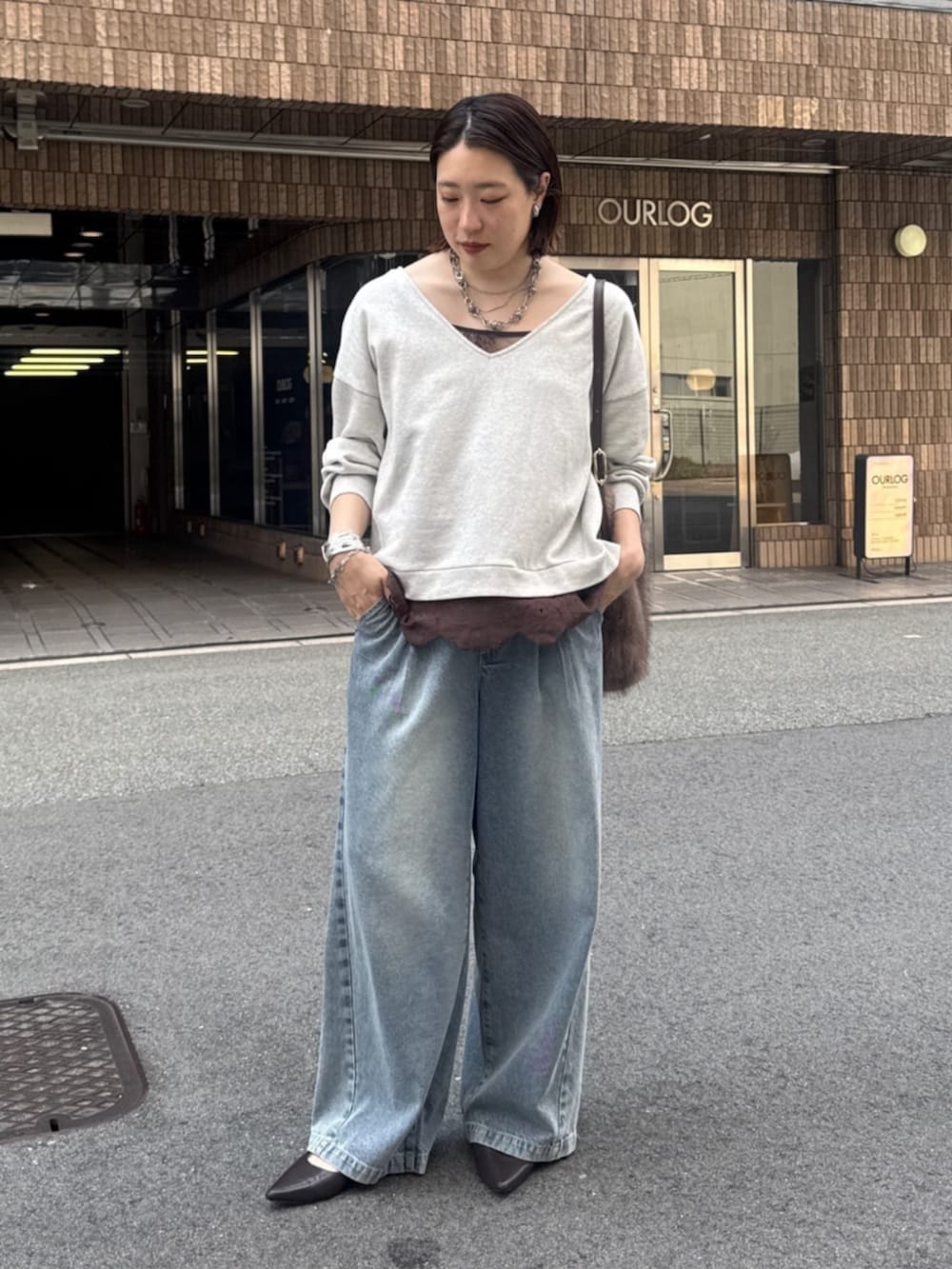 ブルー系のデニムパンツ、ブラウン系のパンプス、ブラウン系のシャツ/ブラウスを着用したレディースの夏コーディネートの3枚目の写真