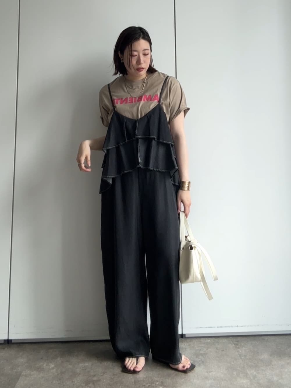 ベージュ系のテーラードジャケット、ベージュ系のTシャツ/カットソー、ブラック系のつなぎ/オールインワンを着用したレディースの夏コーディネートの3枚目の写真