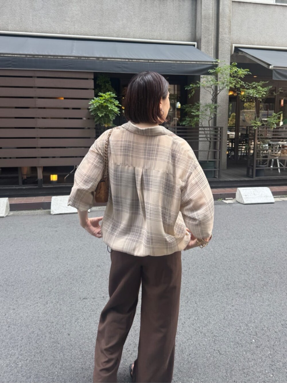 イエロー系のショルダーバッグ、ベージュ系のシャツ/ブラウス、ベージュ系のその他パンツを着用したレディースの夏コーディネートの7枚目の写真