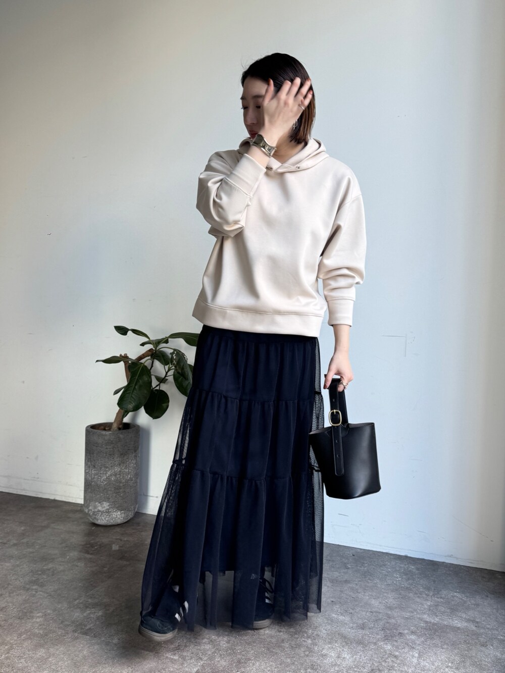 ホワイト系のセットアップ、ブルー系のスカートを着用したレディースの冬コーディネートの3枚目の写真