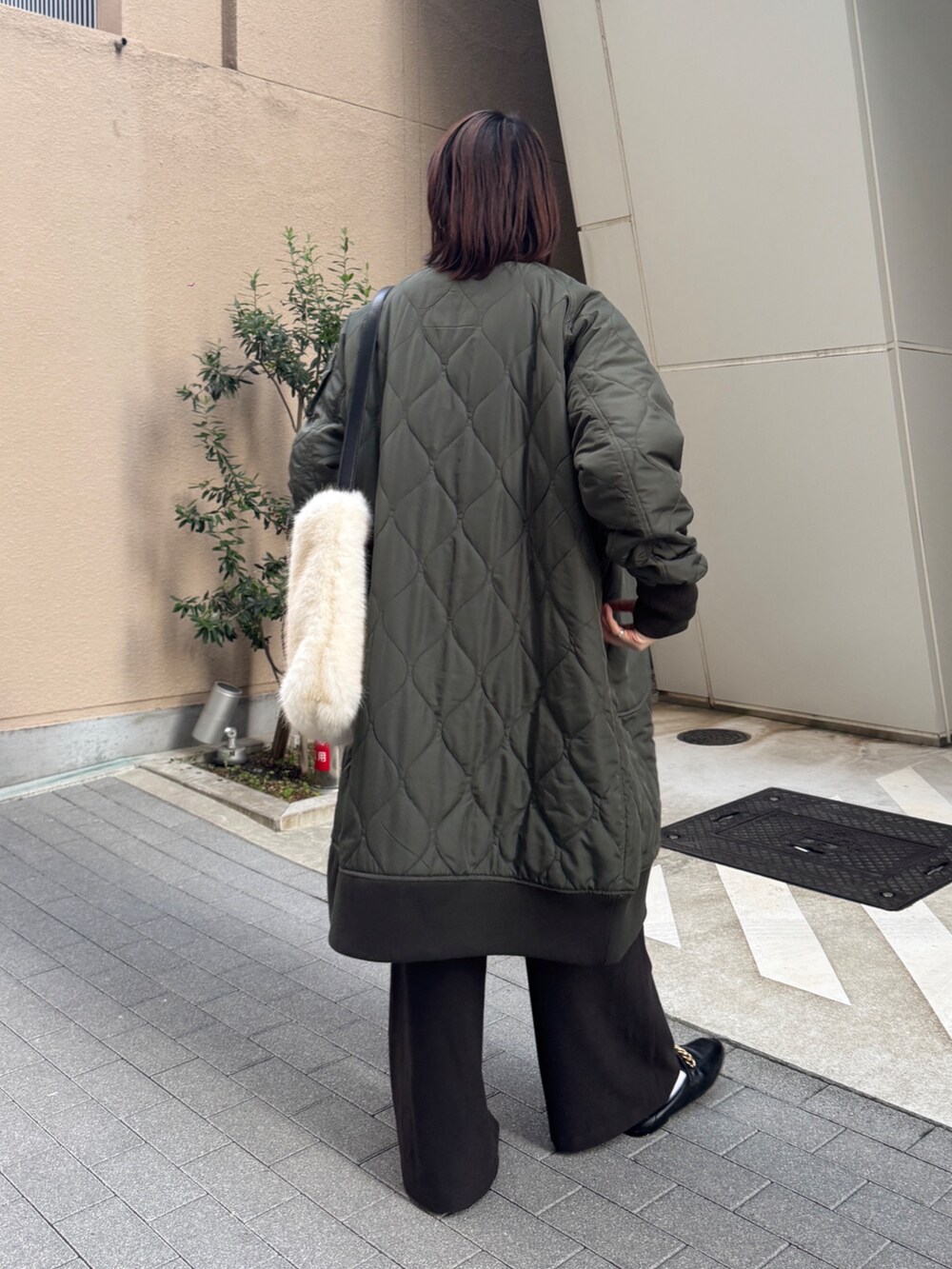 グリーン系のその他アウター、ベージュ系のニット/セーター、ブラウン系のその他パンツを着用したレディースの冬コーディネートの3枚目の写真