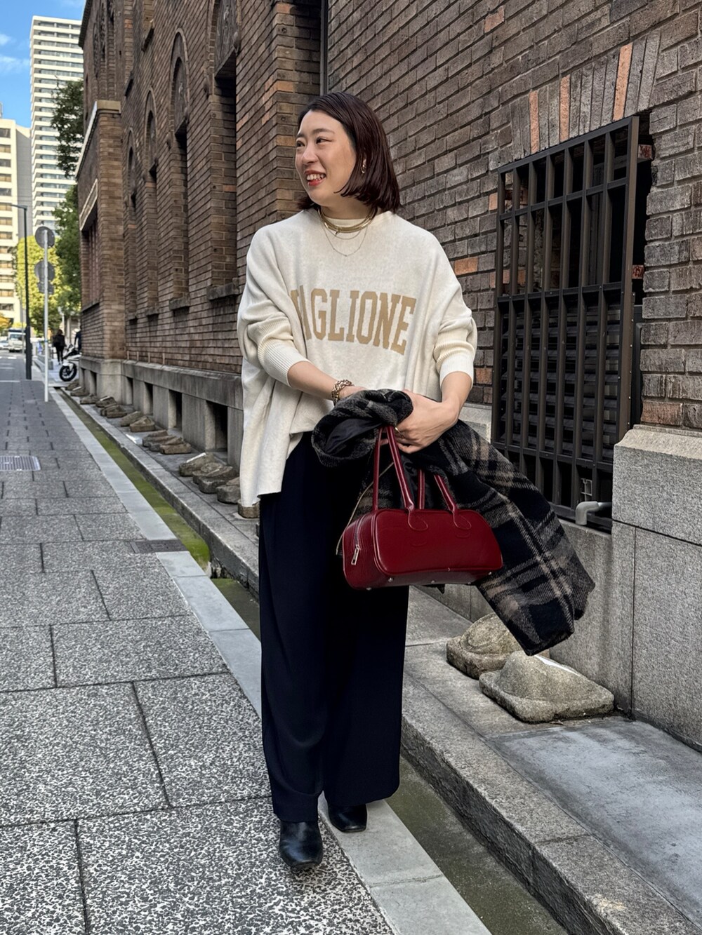 ブルー系のスラックス、ホワイト系のニット/セーター、レッド系のショルダーバッグを着用したレディースの秋コーディネートの8枚目の写真