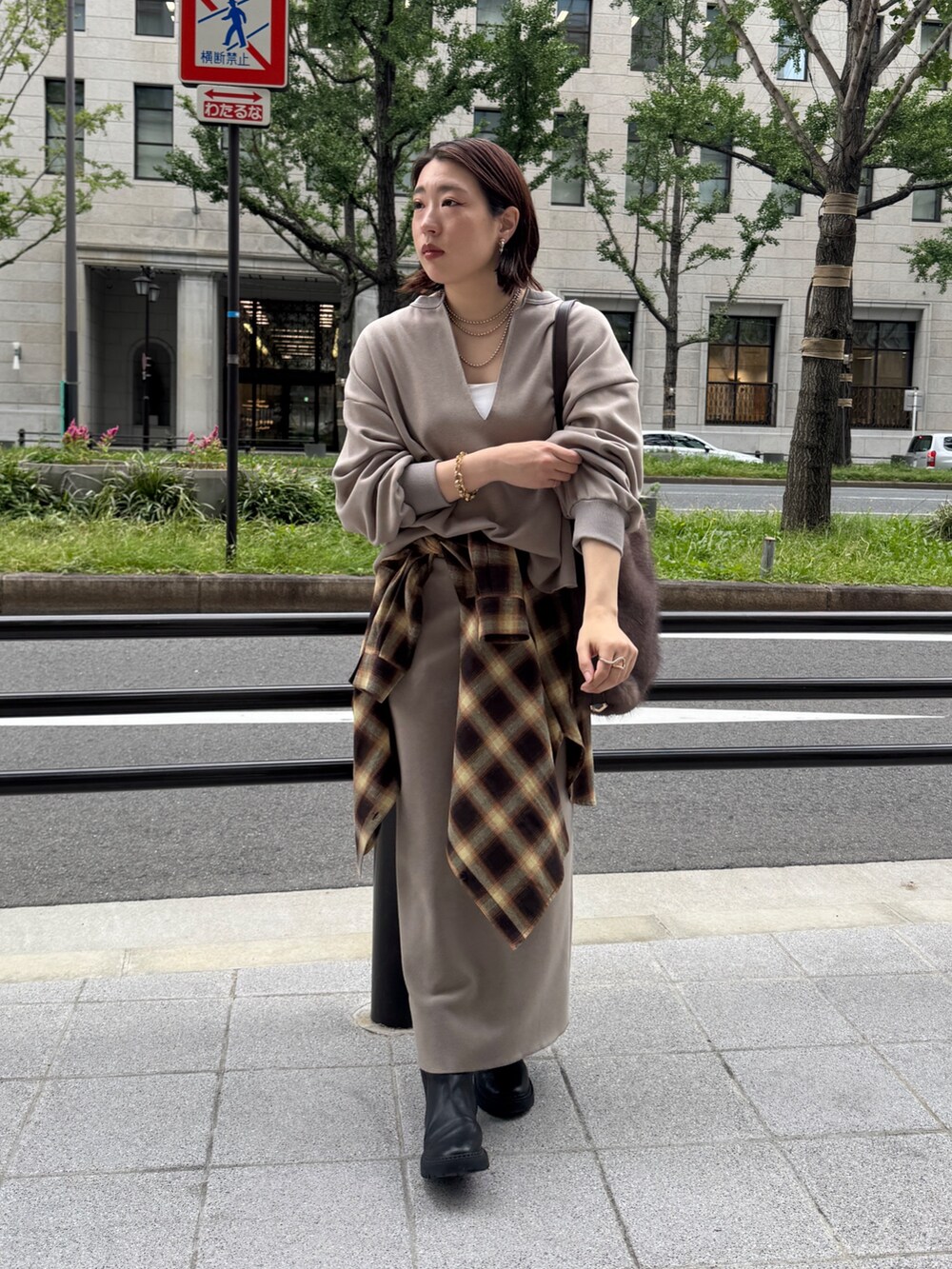 ベージュ系のTシャツ/カットソー、ベージュ系のスカート、ブラウン系のショルダーバッグを着用したレディースの秋コーディネートの3枚目の写真