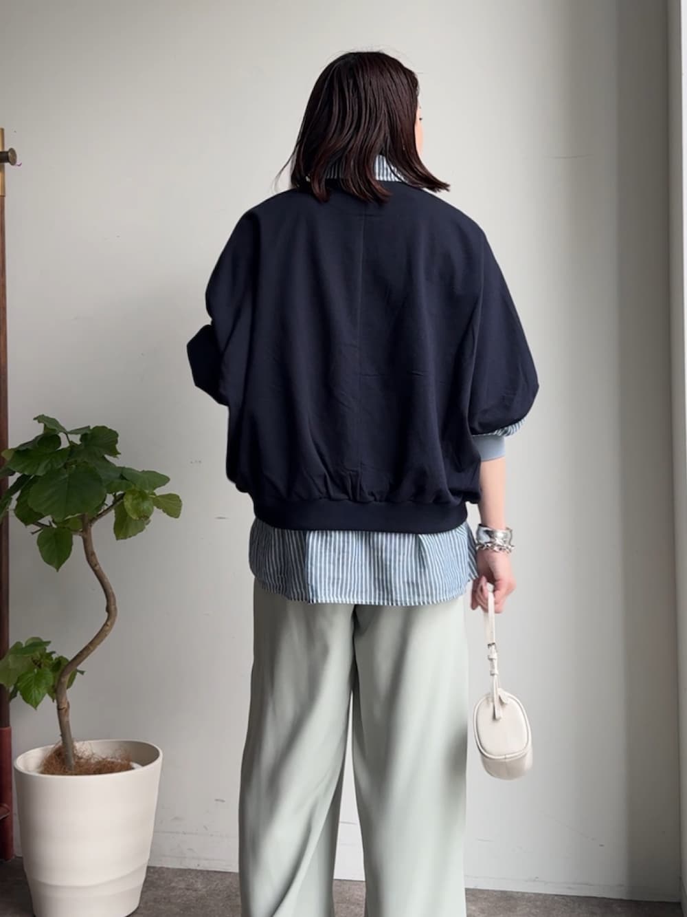 グリーン系のスラックス、ブルー系のシャツ/ブラウス、ブルー系のTシャツ/カットソーを着用したレディースの春コーディネートの3枚目の写真