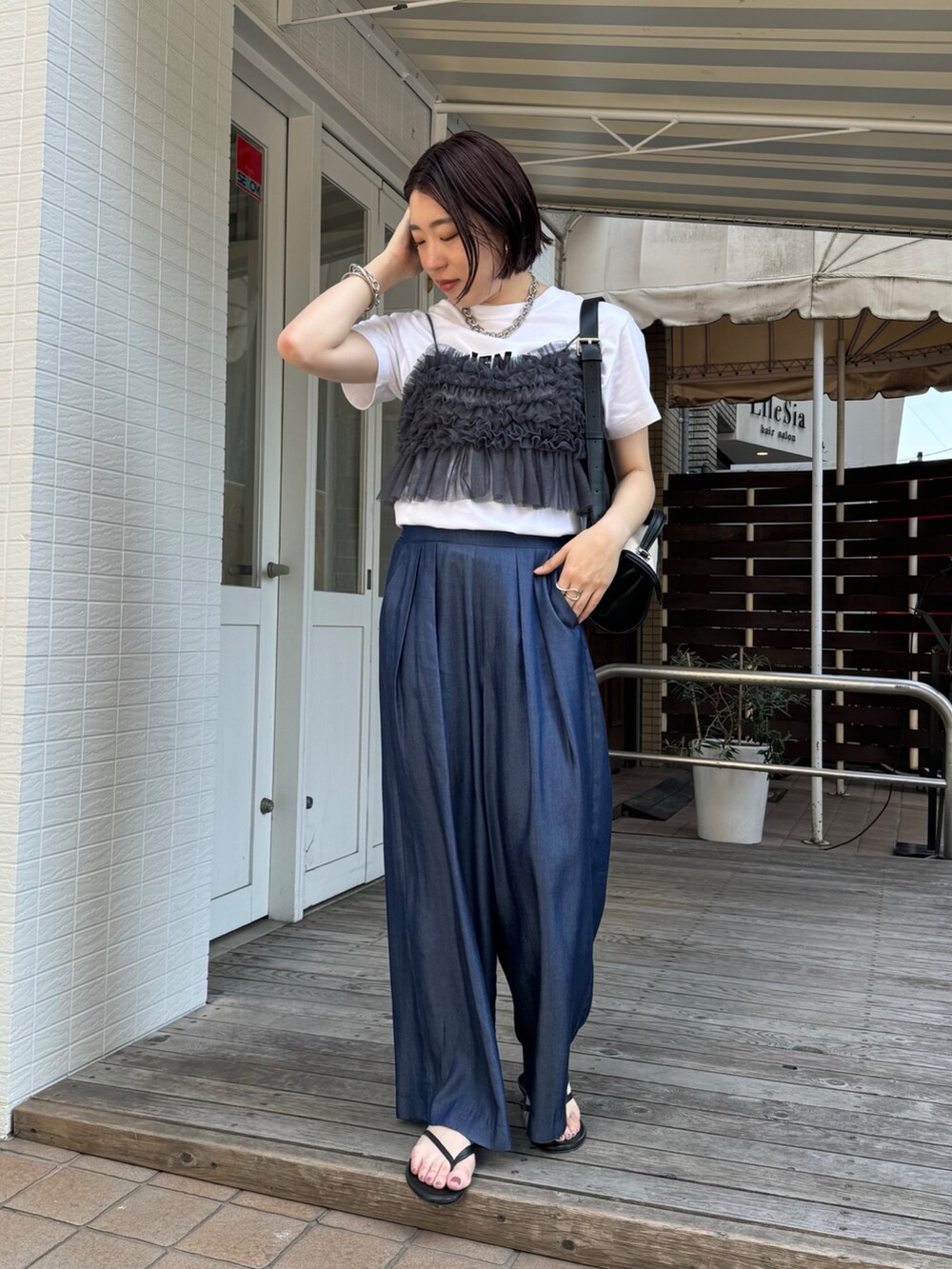 ブルー系のデニムパンツ、ホワイト系のTシャツ/カットソー、グレー系のキャミソールを着用したレディースの夏コーディネートの2枚目の写真