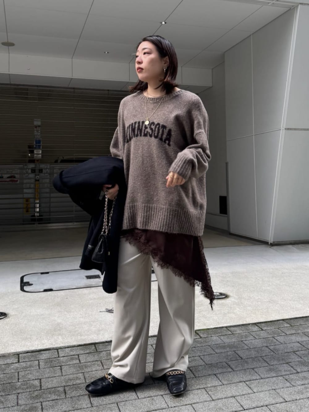 ブラック系のショルダーバッグ、ベージュ系のニット/セーター、ブラウン系のキャミソールを着用したレディースの秋コーディネートの2枚目の写真