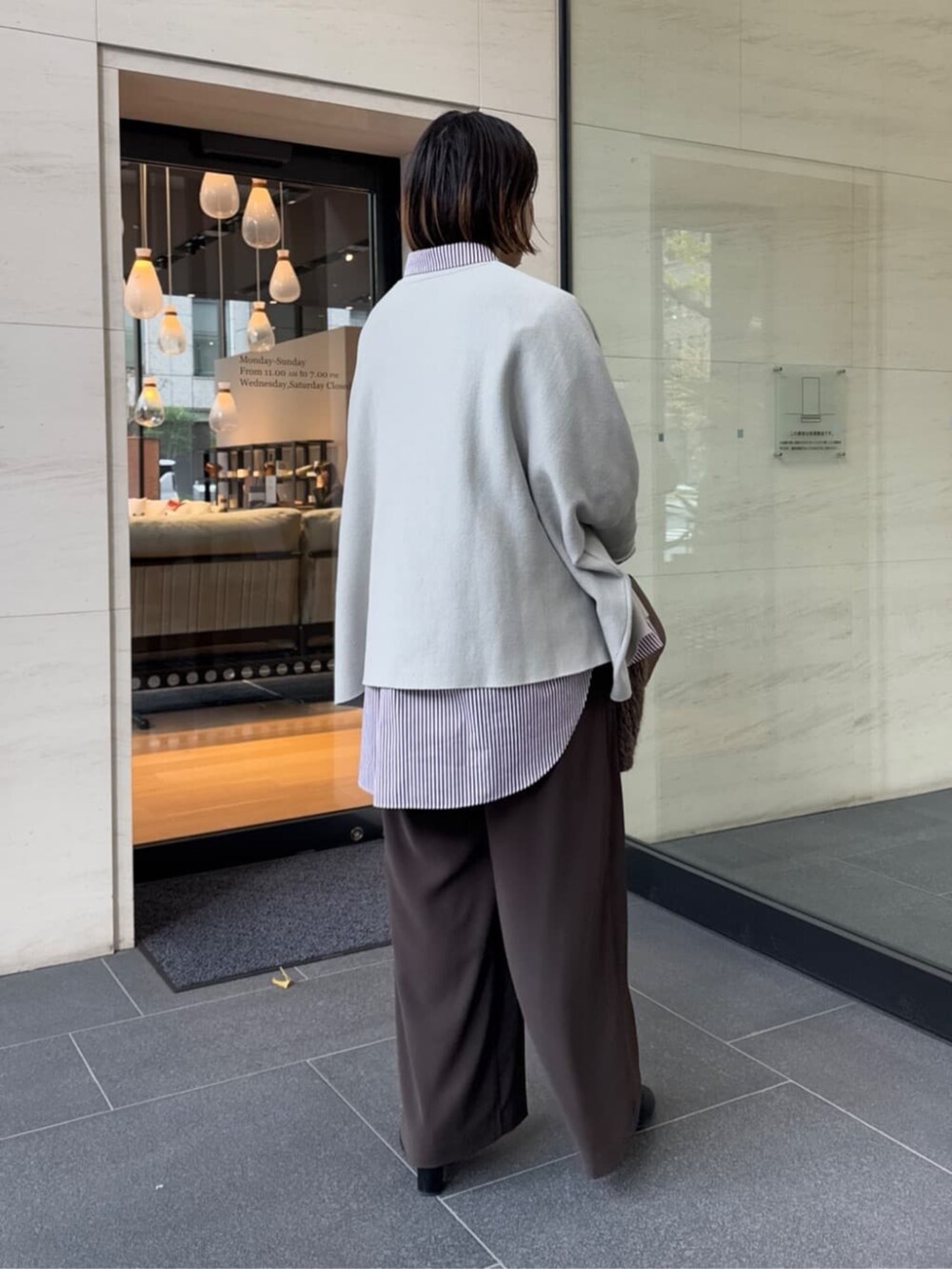 ブラウン系のスラックス、レッド系のシャツ/ブラウス、ブラウン系のショルダーバッグを着用したレディースの冬コーディネートの9枚目の写真