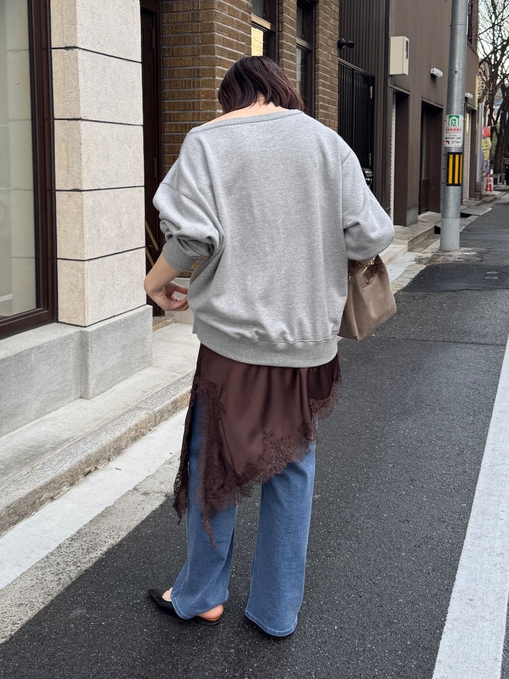 グレー系のTシャツ/カットソー、ブラウン系のキャミソール、ブルー系のデニムパンツを着用したレディースの冬コーディネートの6枚目の写真