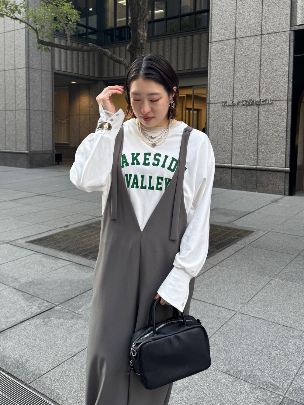 グレー系のつなぎ/オールインワン、ホワイト系のTシャツ/カットソー、シルバー系のネックレスを着用したレディースの冬コーディネートの7枚目の写真