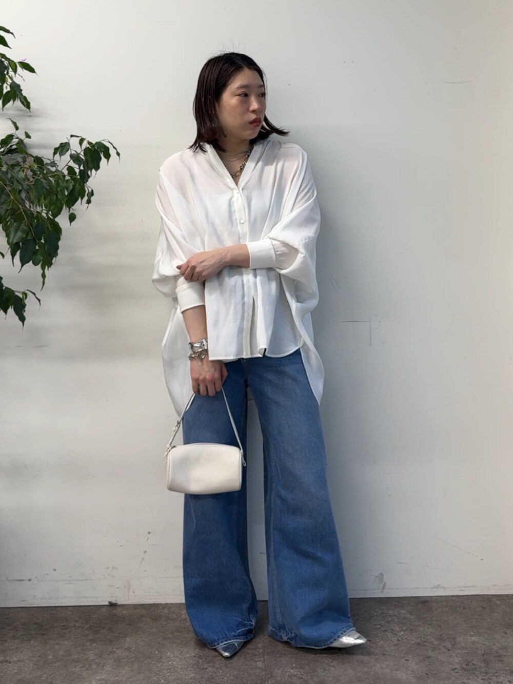 ホワイト系のシャツ/ブラウス、ブルー系のデニムパンツを着用したレディースの冬コーディネートの2枚目の写真