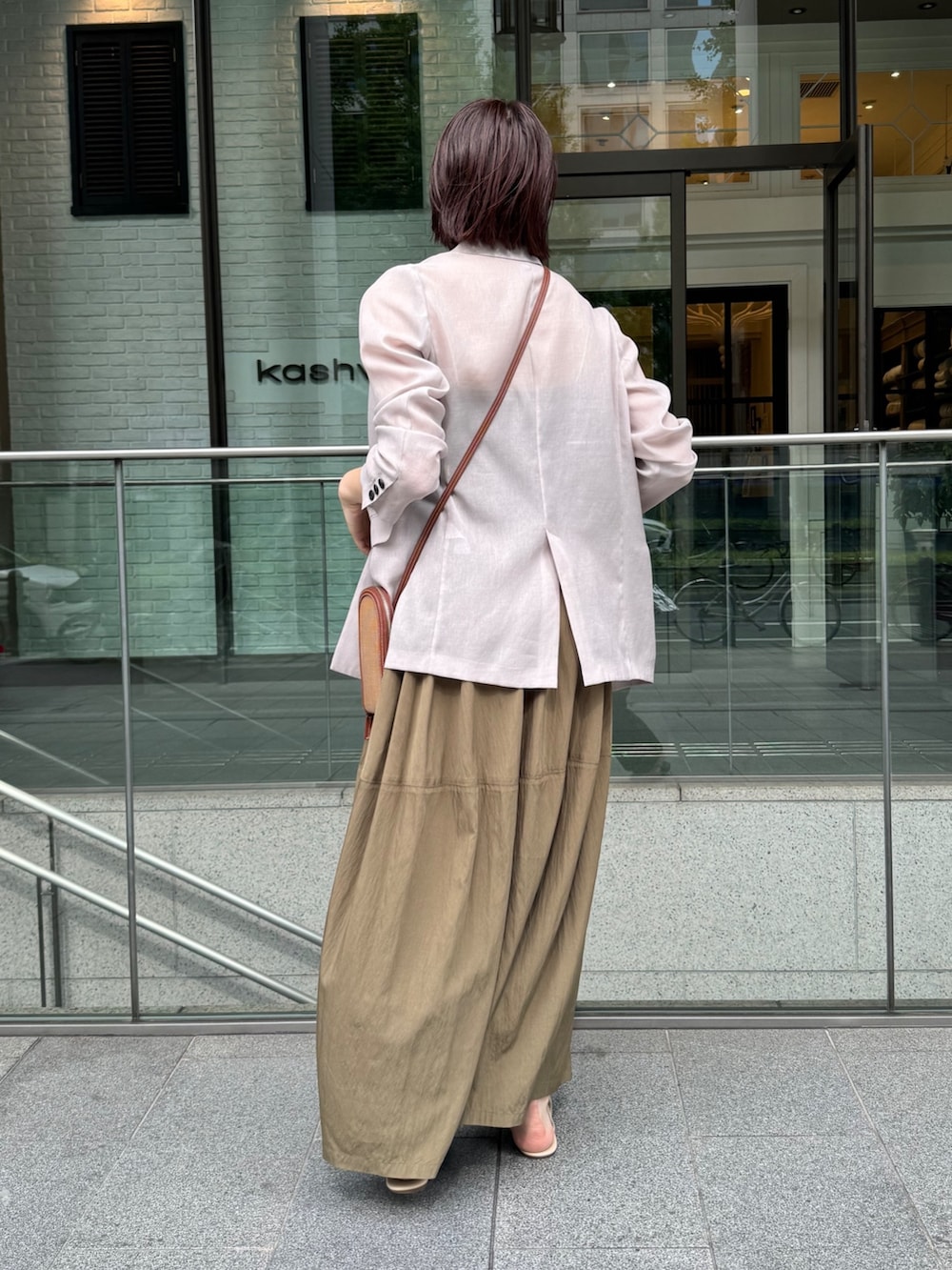 グリーン系のワンピース、ベージュ系のテーラードジャケット、ゴールド系のネックレスを着用したレディースの夏コーディネートの9枚目の写真