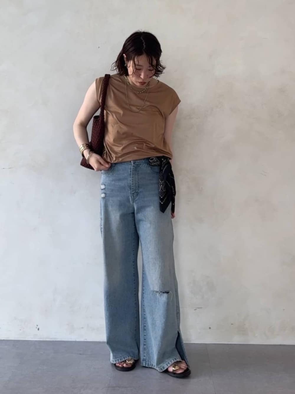 ブルー系のデニムパンツ、ブラウン系のサンダル、イエロー系のTシャツ/カットソーを着用したレディースの夏コーディネートの3枚目の写真