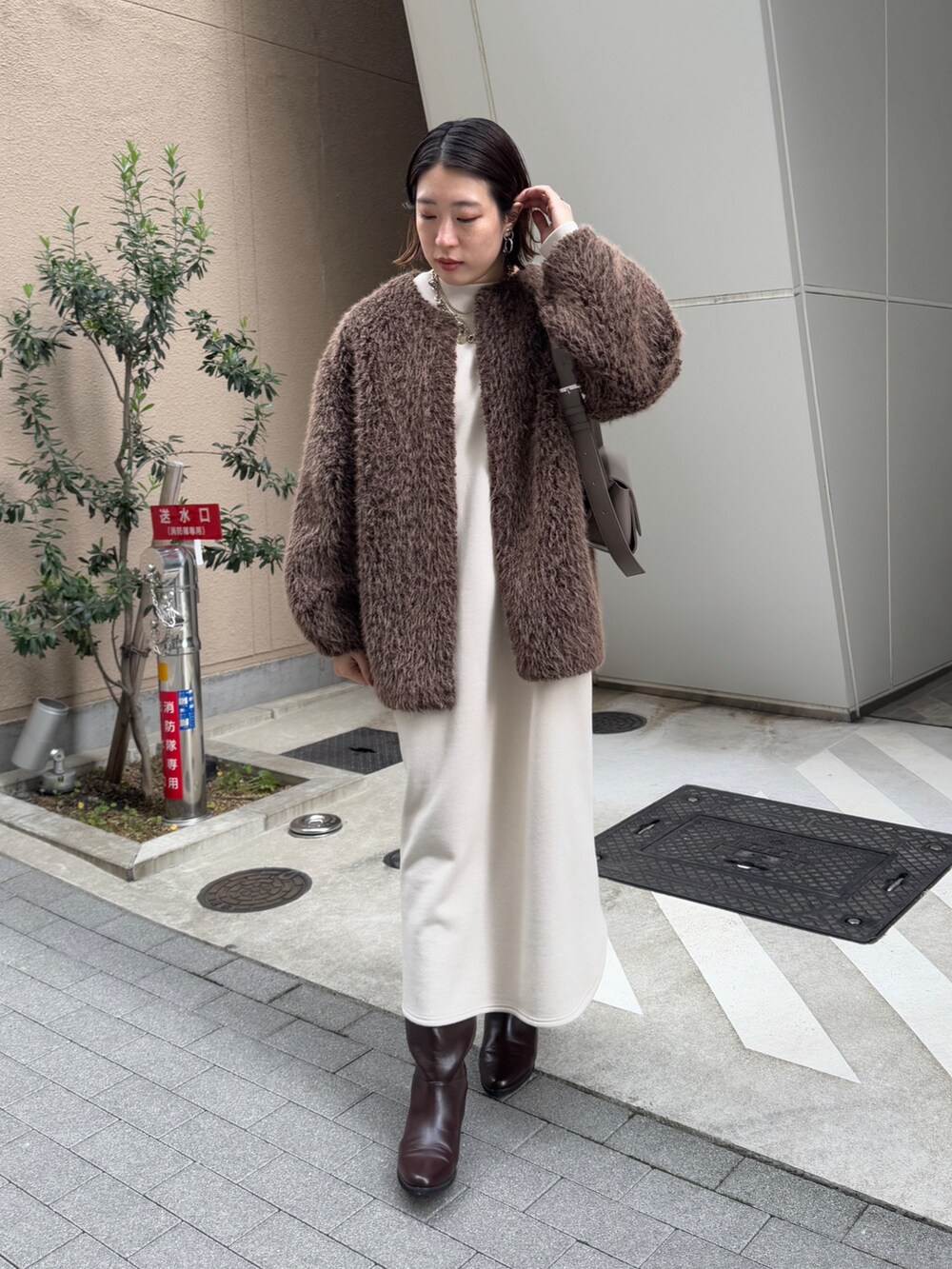 ベージュ系のワンピース、ブラウン系のその他アウター、ブラウン系のブーツを着用したレディースの冬コーディネートの2枚目の写真