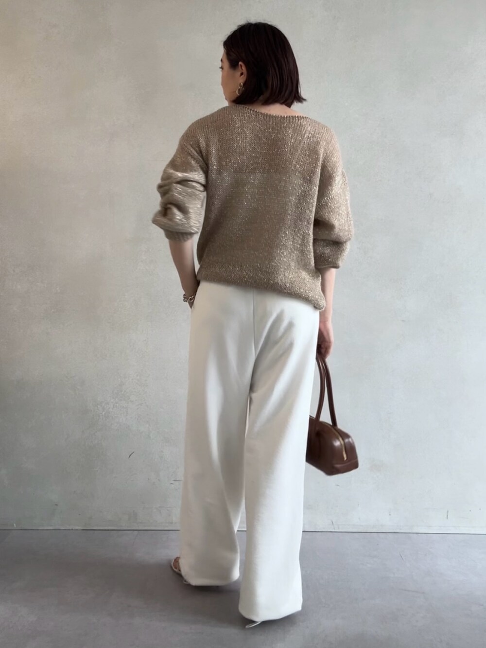 ホワイト系のスウェットパンツ、ベージュ系のニット/セーター、ブラウン系のショルダーバッグを着用したレディースの秋コーディネートの5枚目の写真