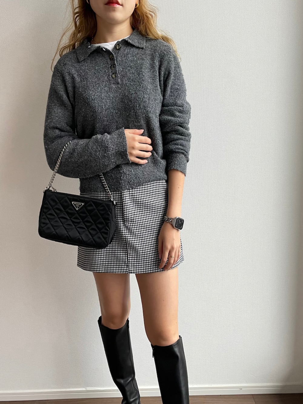 ブラック系のスカート、ブラック系のブーツ、ブラック系のハンドバッグを着用したレディースの秋コーディネートの2枚目の写真