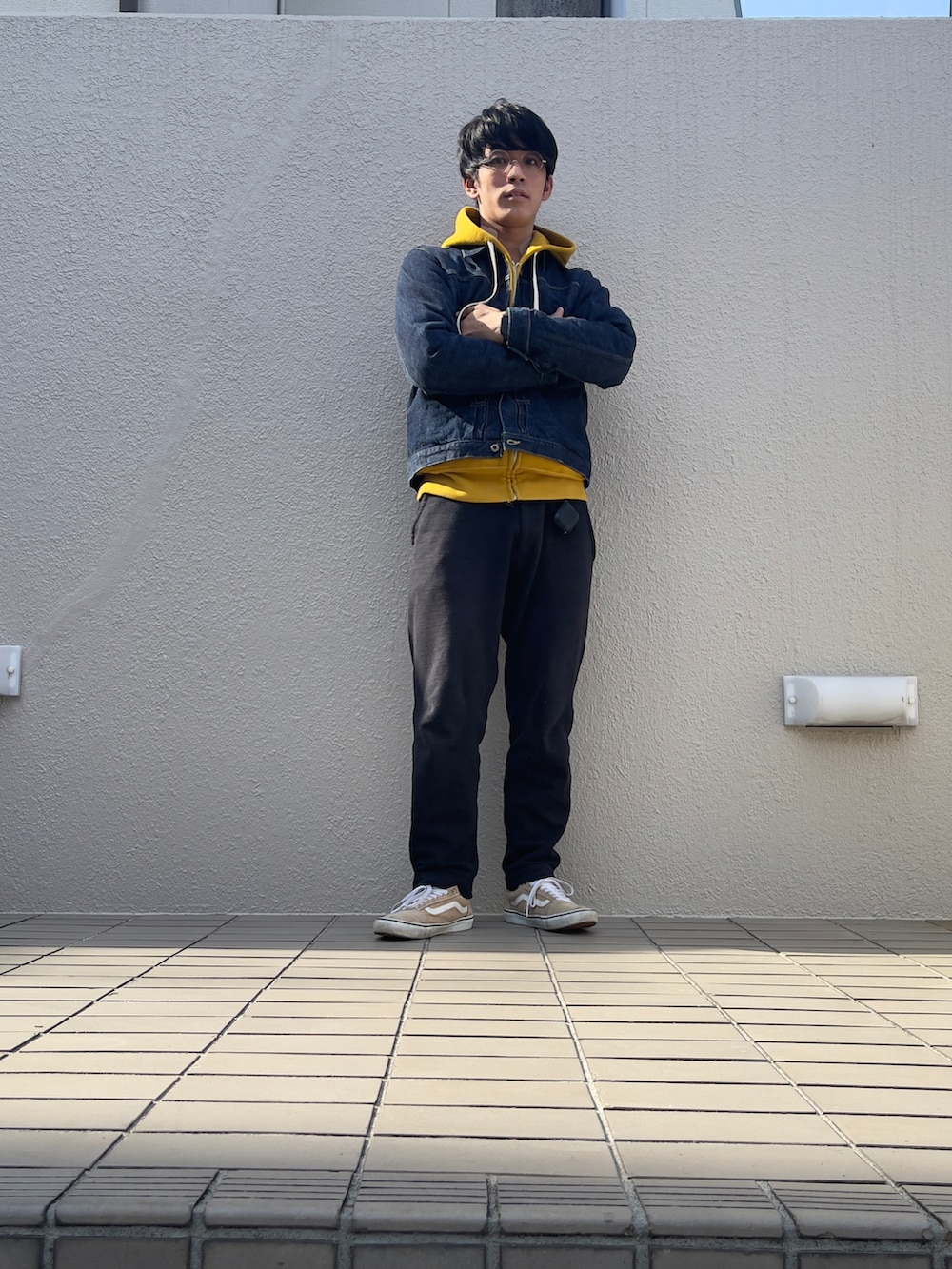 ブルー系のデニムジャケット、ブラック系のスウェットパンツ、ベージュ系のスニーカーを着用したメンズの秋コーディネートの3枚目の写真