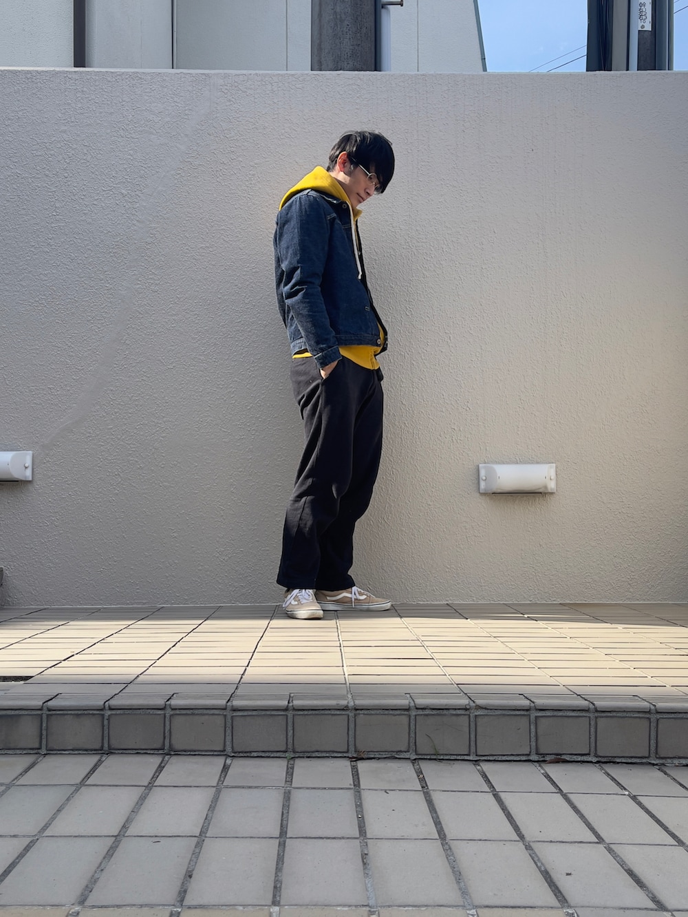 ブルー系のデニムジャケット、ブラック系のスウェットパンツ、ベージュ系のスニーカーを着用したメンズの秋コーディネートの2枚目の写真