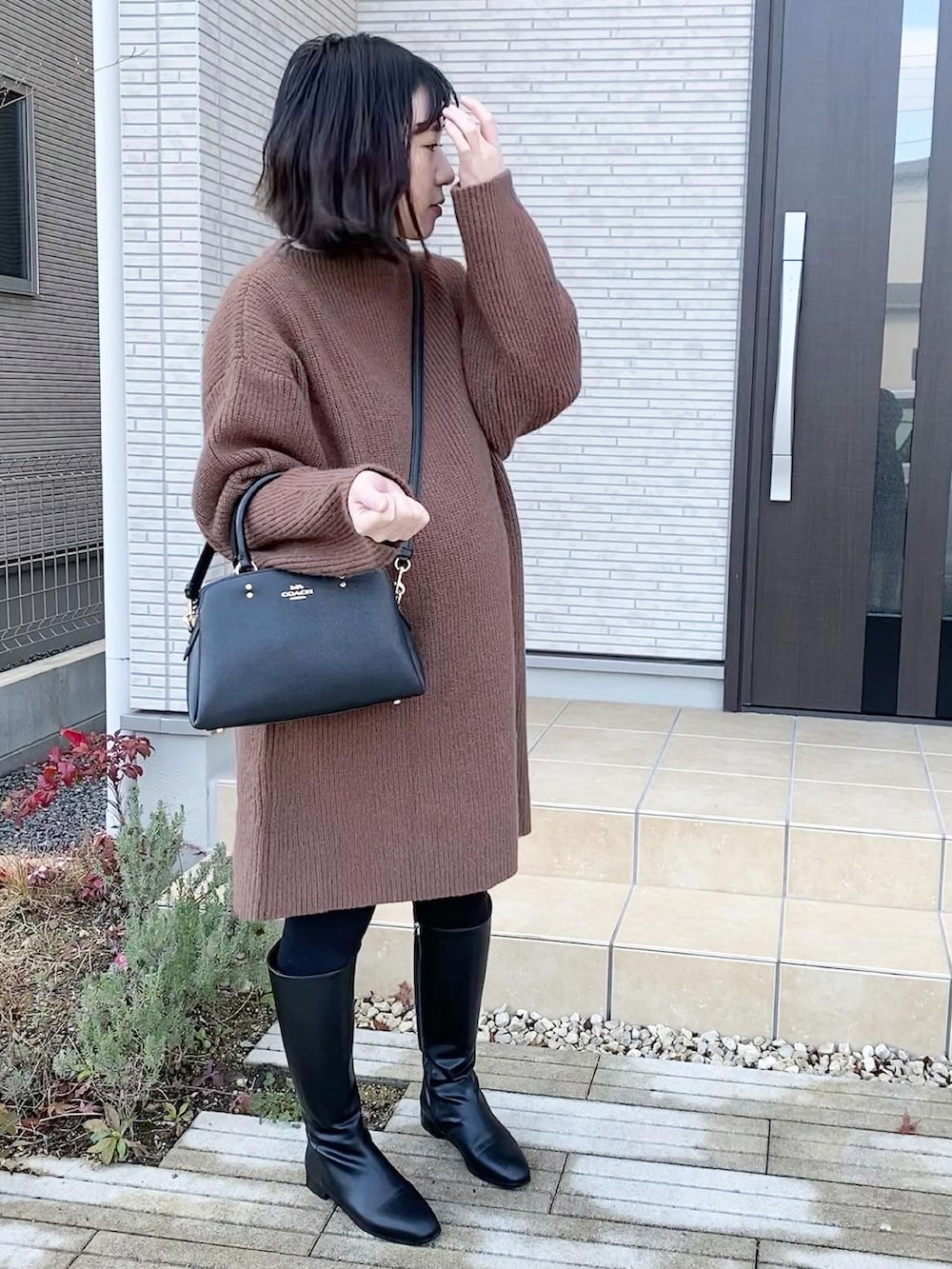 「妊婦コーデ、女の子ママ、臨月、ロングブーツ、ニットワンピース、ブラウン、ブーツ、冬コーデ、大人カジュアル、シンプルスタイル、カジュアルコーデ、大人可愛い、お出かけコーデ、オトナ女子、秋冬コーデ」｜「COACHのアイテム（ショルダーバッグ、ブラック系）」を使った、AYUMIさん（レディース・157cm）の冬コーディネートの2枚目の写真