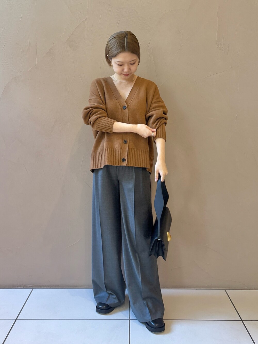 グレー系のスラックスを着用したレディースの秋コーディネートの2枚目の写真