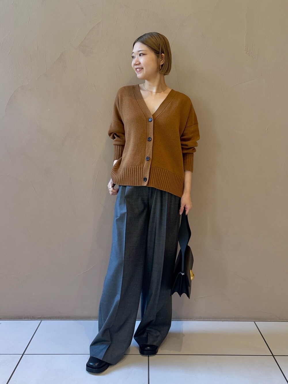 グレー系のスラックスを着用したレディースの秋コーディネートの3枚目の写真