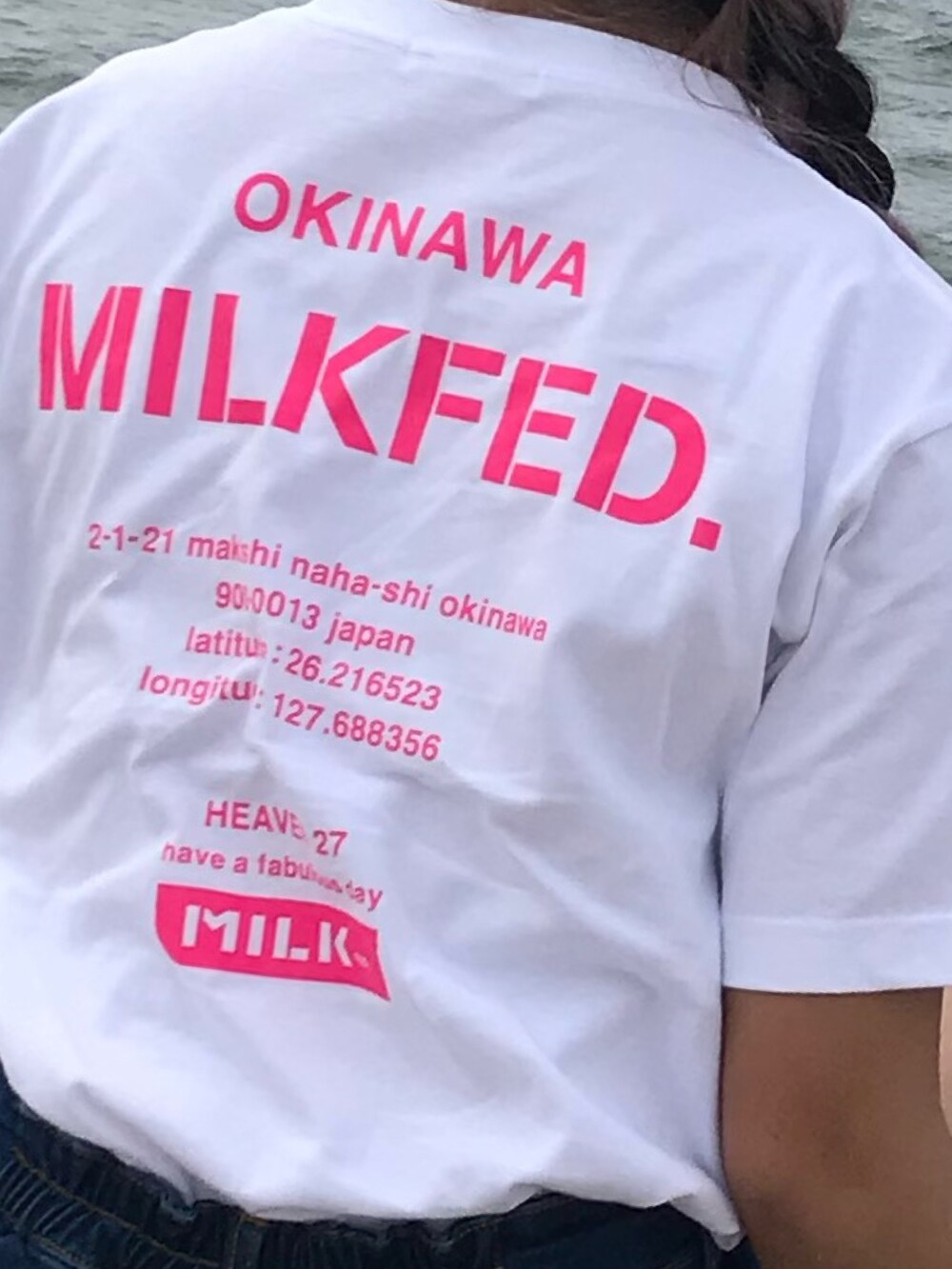 ホワイト系のスニーカー、ブルー系のニット/セーター、ホワイト系のTシャツ/カットソーを着用したレディースの秋コーディネートの3枚目の写真