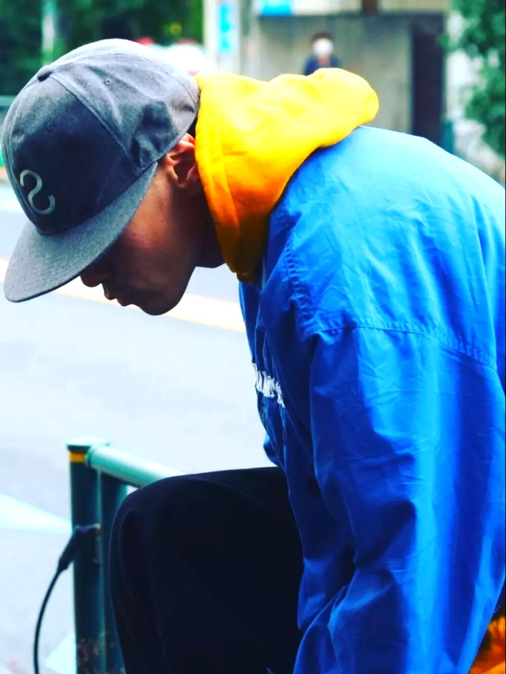 ブラック系のデニムパンツ、イエロー系のパーカー、ブルー系のその他トップスを着用したメンズの秋コーディネートの3枚目の写真