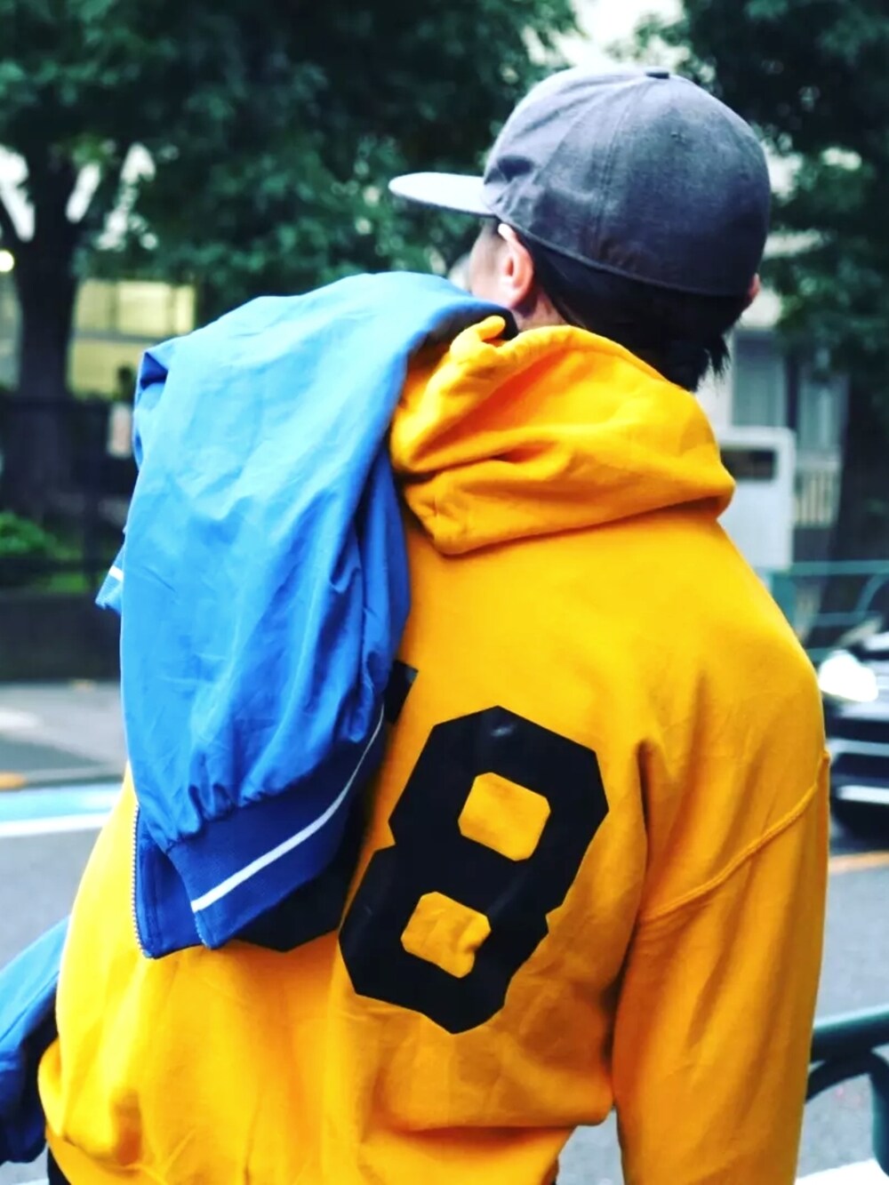 ブラック系のデニムパンツ、イエロー系のパーカー、ブルー系のその他トップスを着用したメンズの秋コーディネートの2枚目の写真