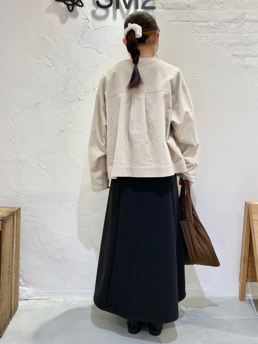 オレンジ系のカーディガン/ボレロ、ホワイト系のノーカラージャケット、ブラウン系のショルダーバッグを着用したレディースの秋コーディネートの3枚目の写真