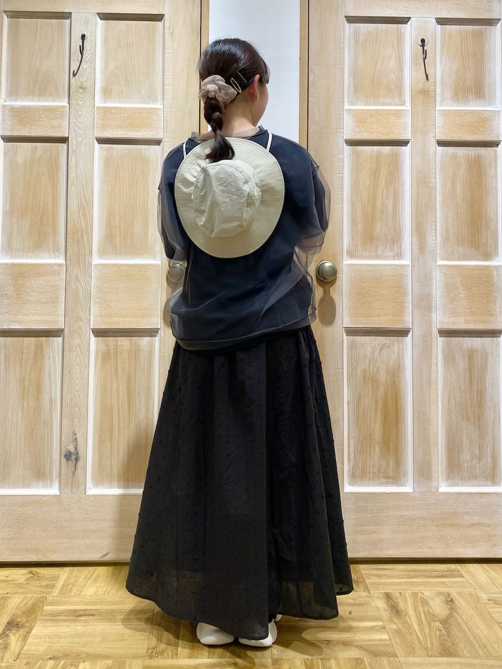 グレー系のTシャツ/カットソー、ブラック系のスカート、ベージュ系のハットを着用したレディースの春コーディネートの3枚目の写真