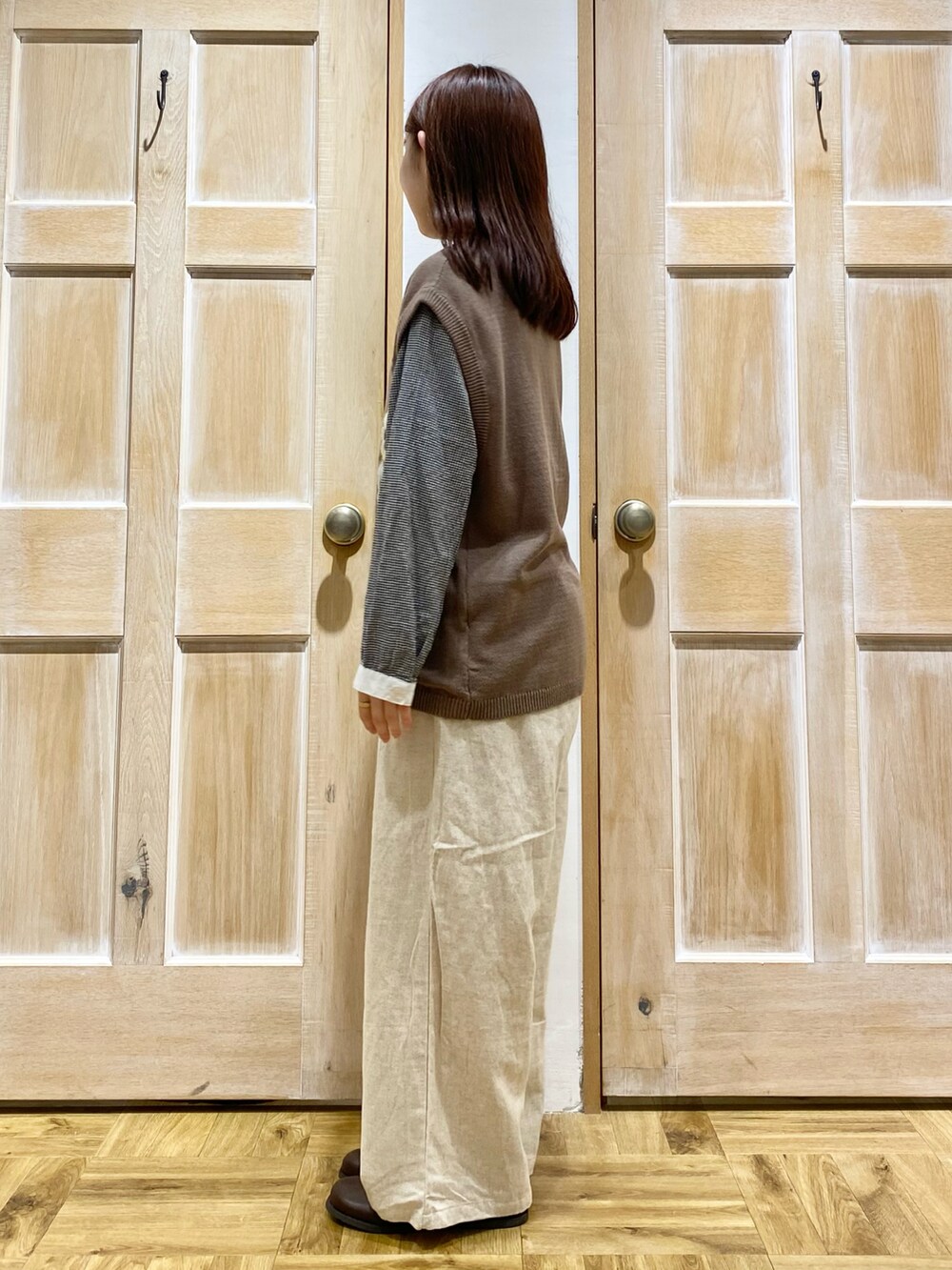 ブラック系のシャツ/ブラウス、ブラウン系のベスト、ホワイト系のその他パンツを着用したレディースの秋コーディネートの2枚目の写真