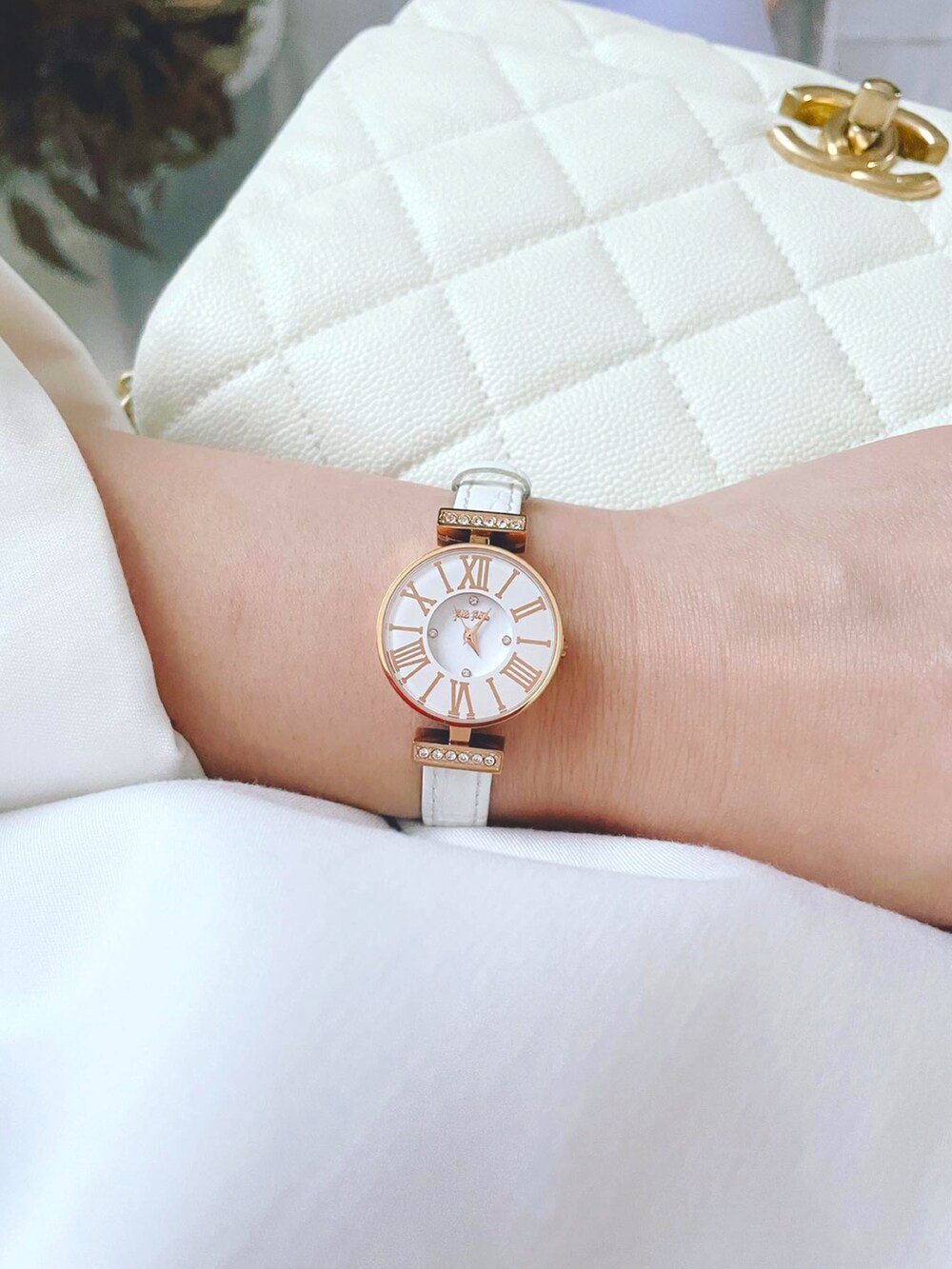 パープル系のスラックス、パープル系のパンプス、ホワイト系の腕時計を着用したレディースの秋コーディネートの3枚目の写真