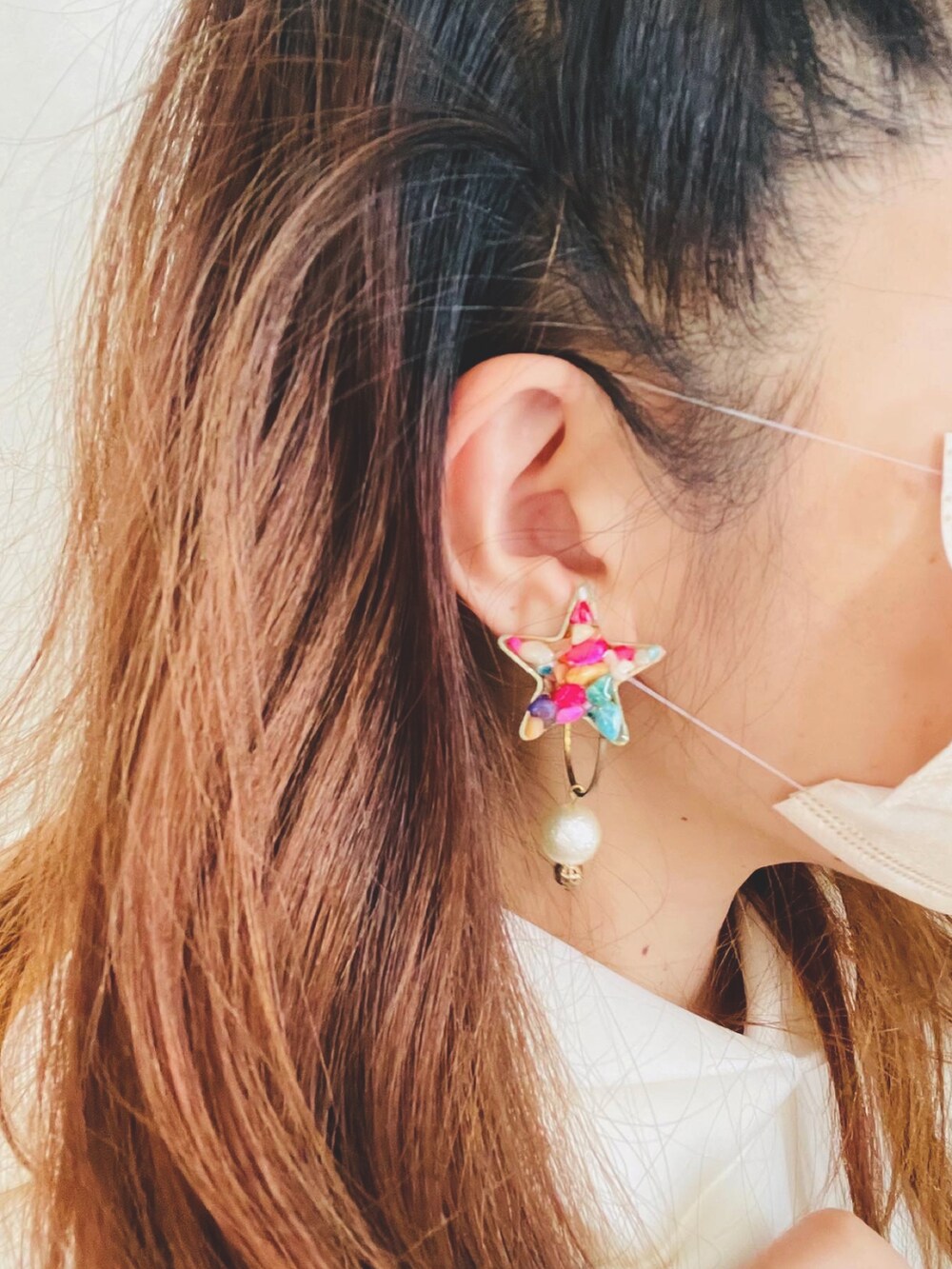 ホワイト系のパーカー、ブルー系のスカート、ベージュ系のショルダーバッグを着用したレディースの秋コーディネートの3枚目の写真